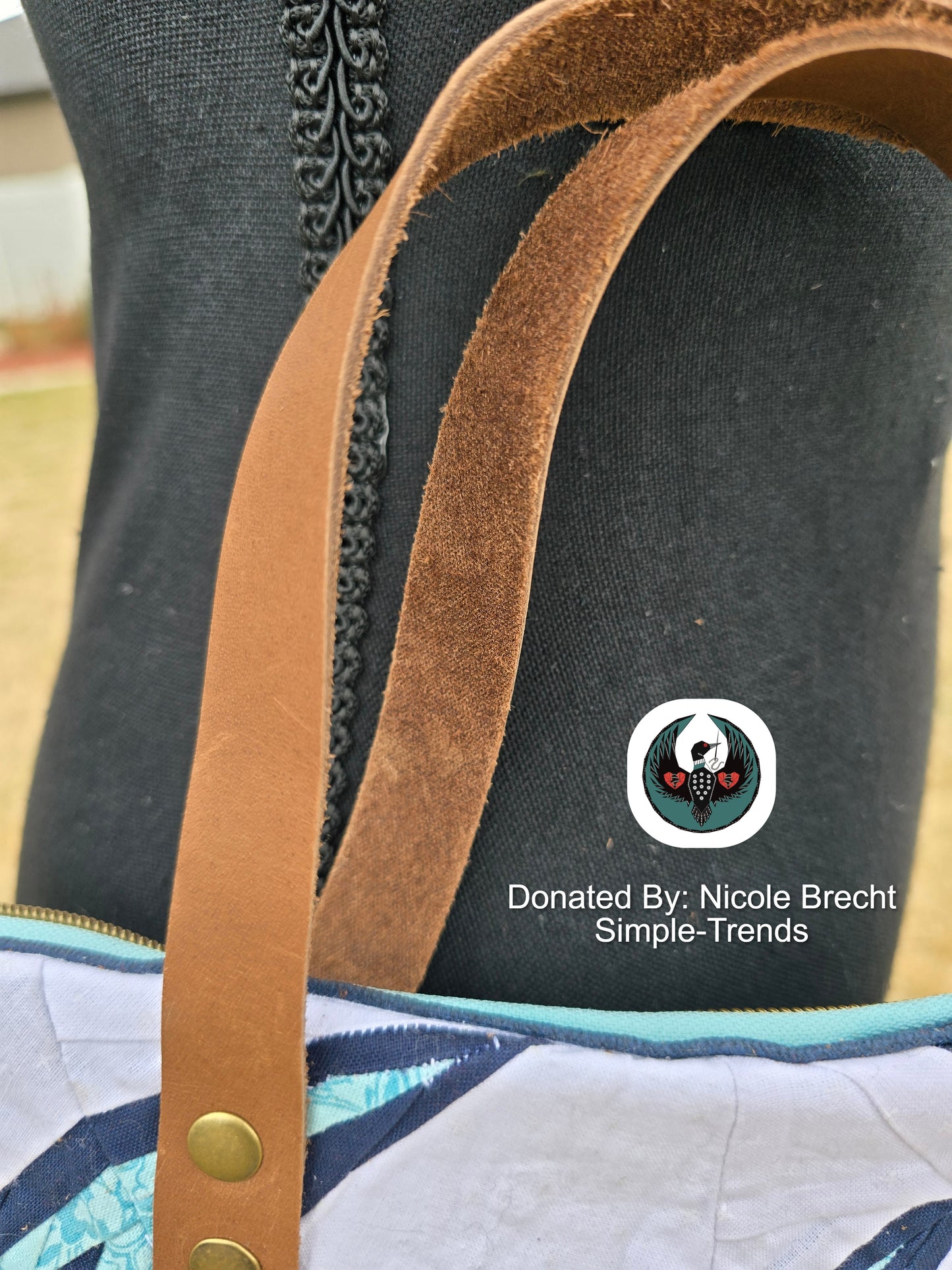 Close-up of a bag with brown leather strap handles