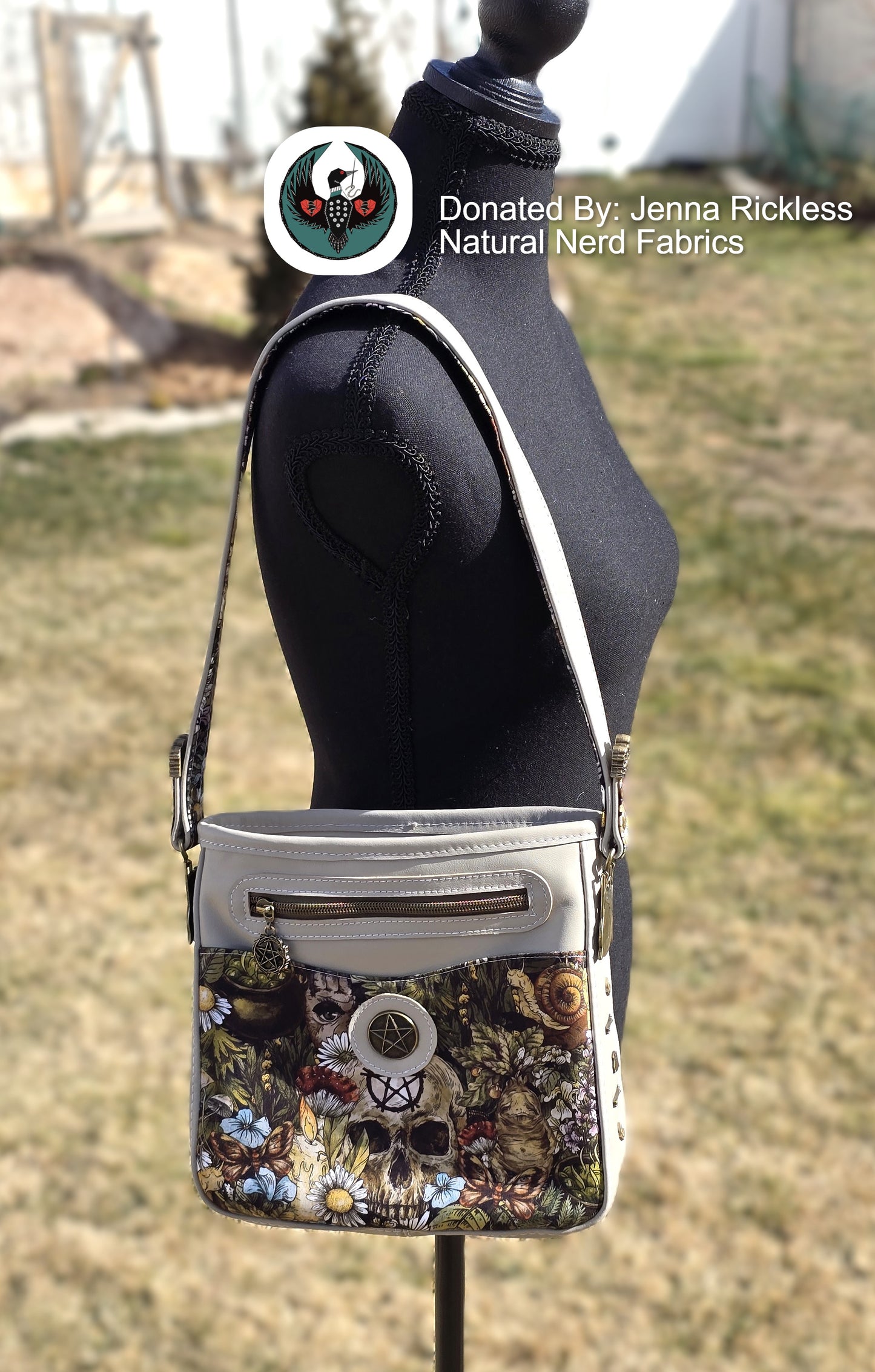 cream leather Crossbody bag with a witchy floral and skull design on a mannequin against a grassy background