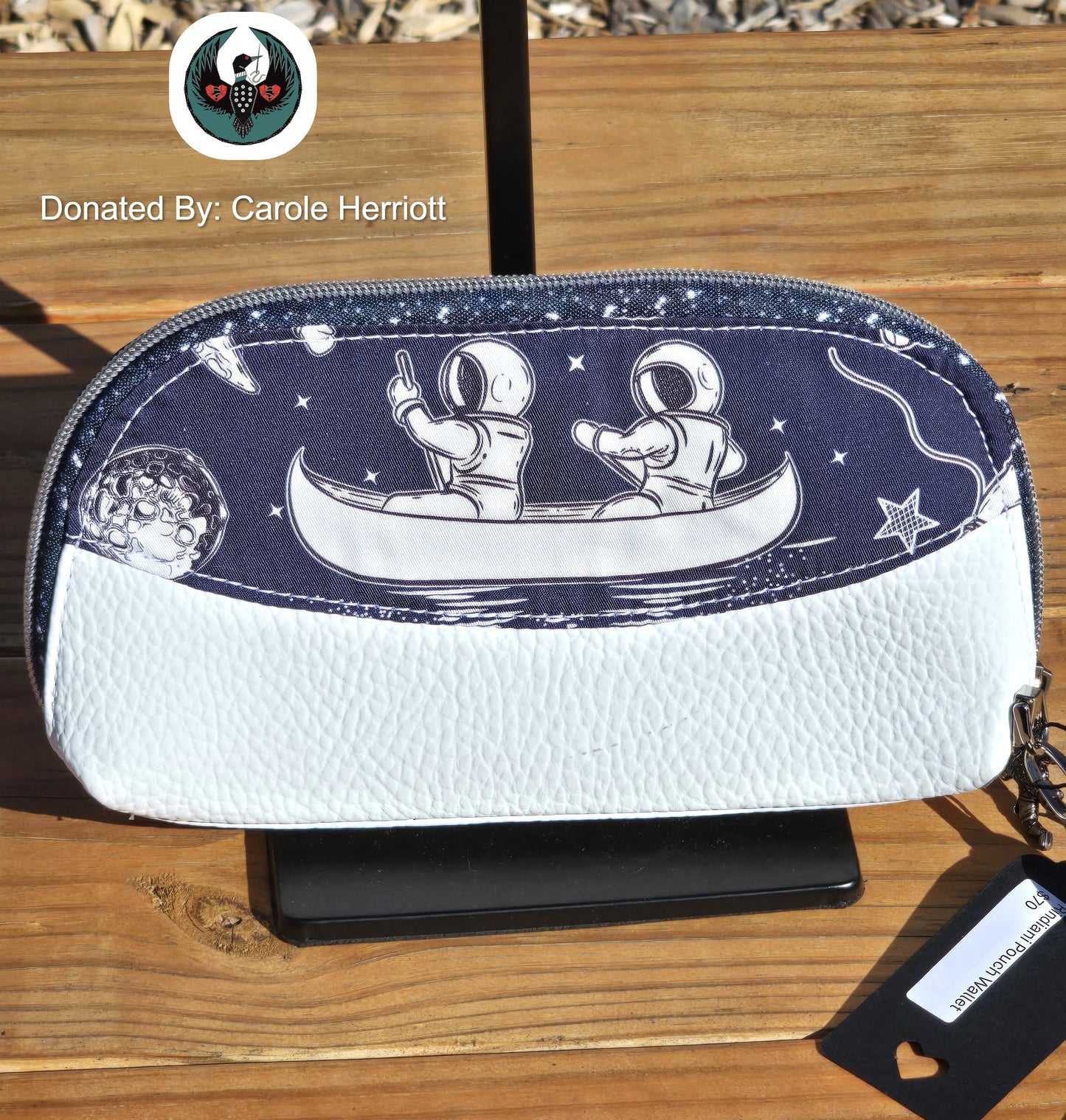 white and navy wallet wristlet with an astronaut design on a wooden surface