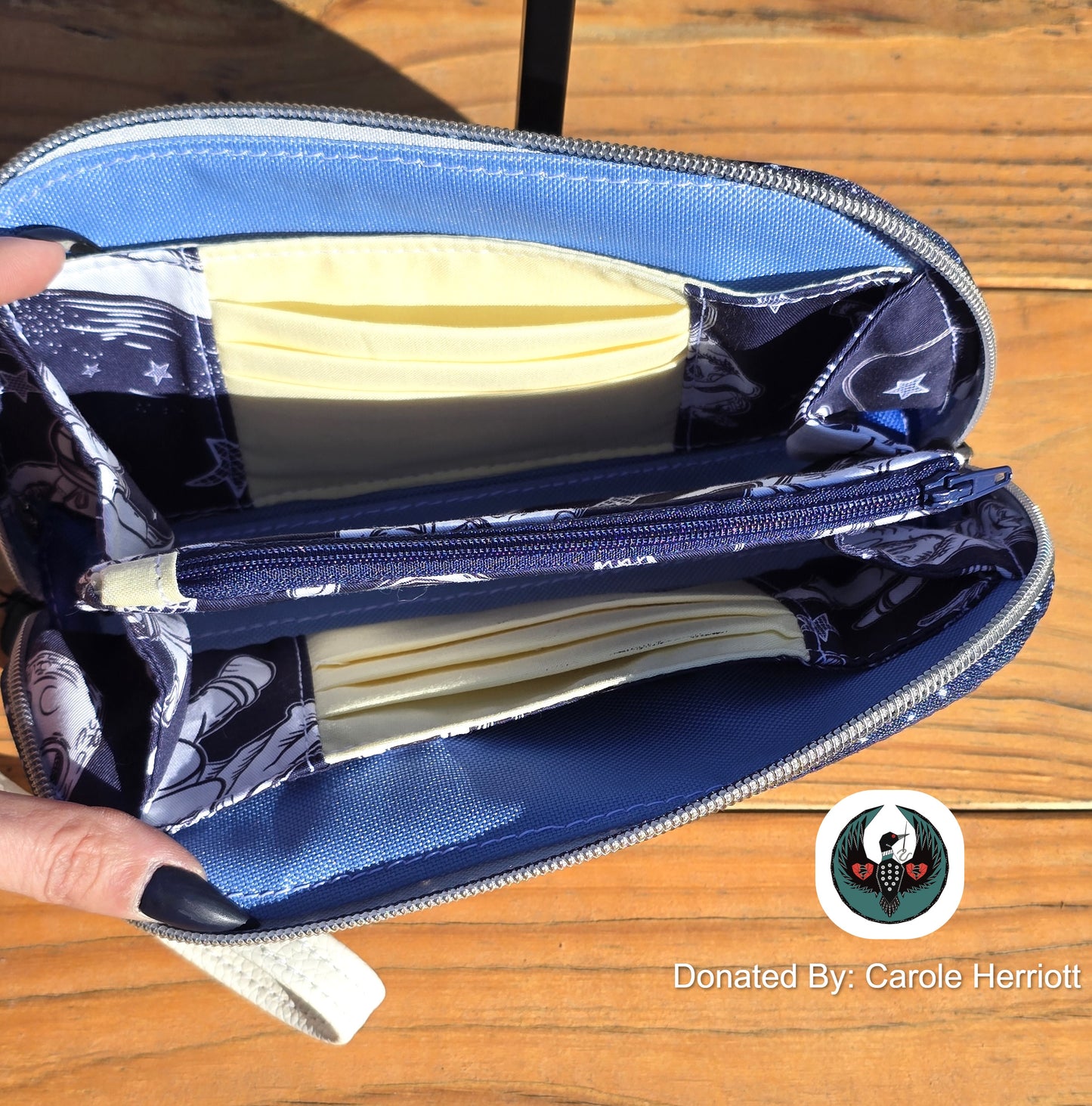 Interior of the astronaut wristlet showing a zipper coin pouch, slip pockets, and card slots.