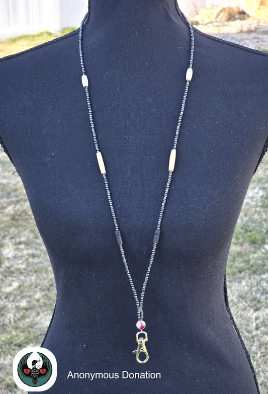 beaded lanyard on a mannequin, featuring gunmetal and bronze colored beads with white and tan accents