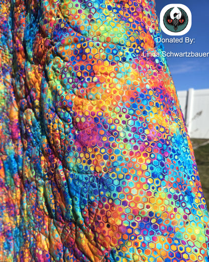 Close-up of a colorful, patterned fabric with a blue sky background