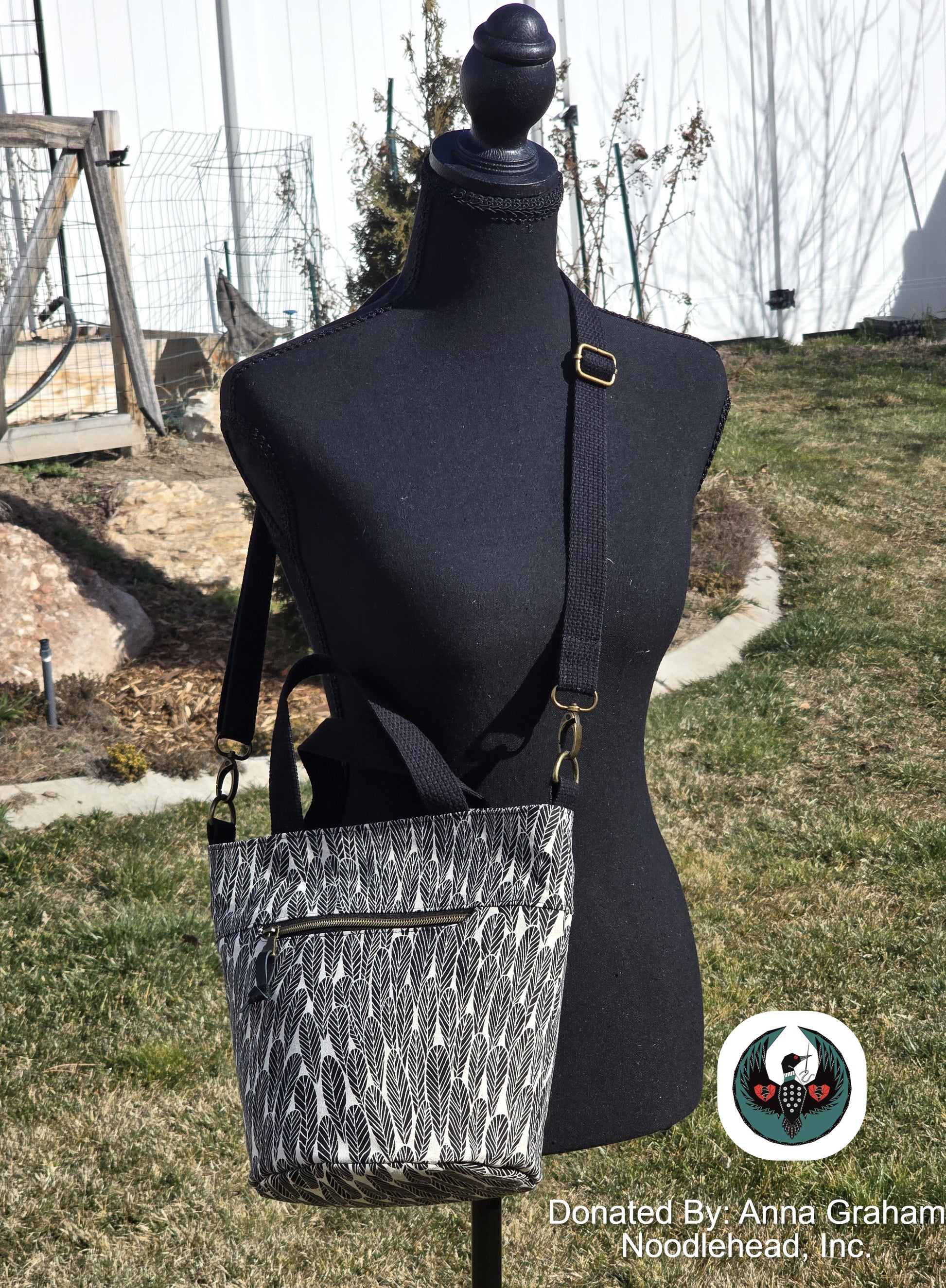 Black and white patterned bucket bag on a mannequin against an outdoor background