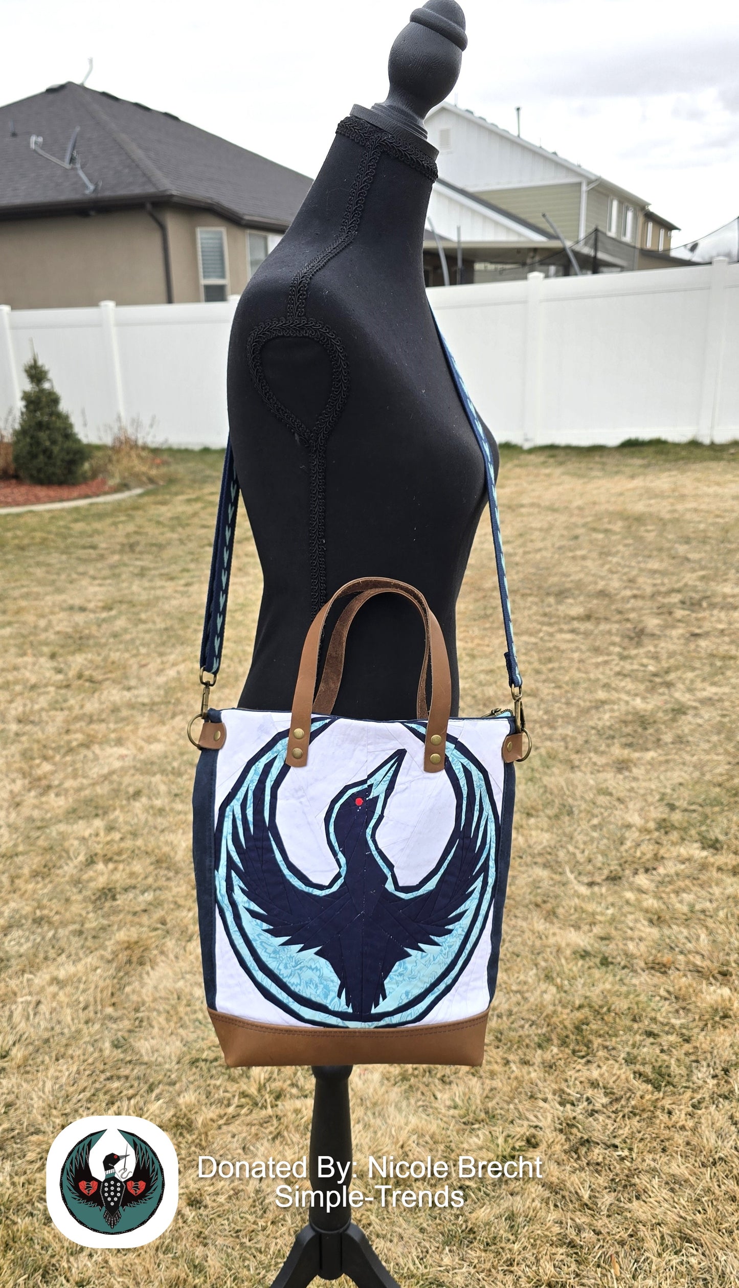 Handbag with a paper pieced Minnesota resist loon on the front hanging across a mannequin