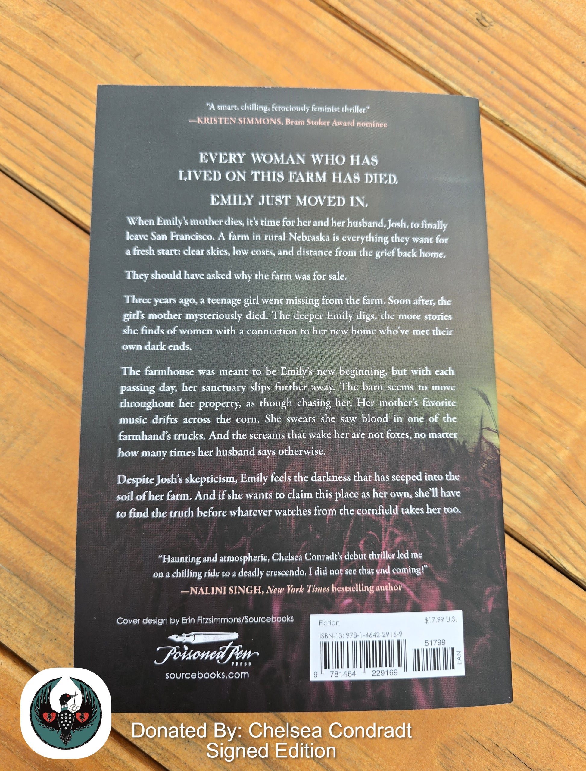 Back cover of a book with text and a barcode on a wooden surface