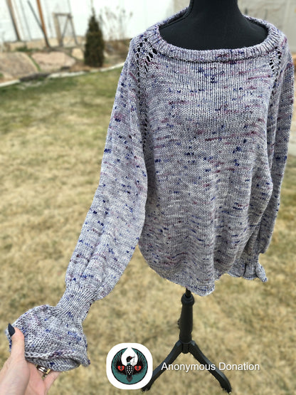 Gray speckled sweater on a mannequin with a blurred outdoor background