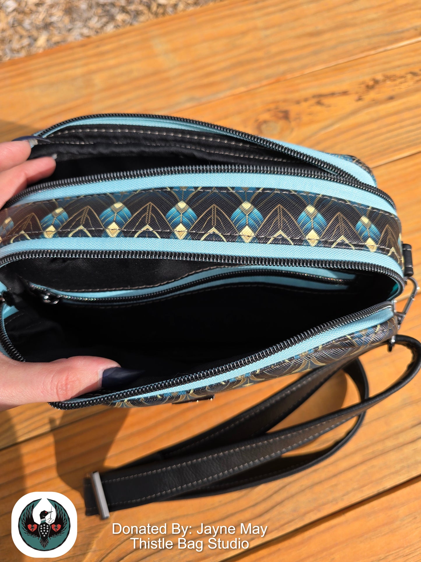Handbag with geometric pattern on a wooden surface, donated by Jayne May Thistle Bag Studio.