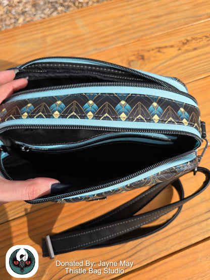 Handbag with geometric pattern on a wooden surface, donated by Jayne May Thistle Bag Studio.